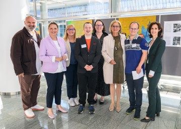 Von links nach rechts: Künstler Krassimir Kolev, Landesrätin Susanne Rosenkranz, AMS-Landesgeschäftsführerin Sandra Kern, Model Simon Couvreur, Initiatorin Nicole Steinacher, Landeshauptfrau Johanna Mikl-Leitner, Model Helmut Trimmel und die Geschäftsführerin von „MAG – Menschen und Arbeit“, Claire-Sophie Mörsen.