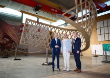 Bundesminister Martin Kocher, Landeshauptfrau Johanna Mikl-Leitner und Stefan Graf vor der Holzskulptur