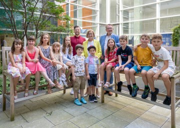 Landeshauptfrau Johanna Mikl-Leitner mit (li.) Umut Adiyaman (Schulische Tagesbetreuung/Ferienbetreuung, NÖ Familienland) und (re.) Klaus Scheidl (stv. Obmann der DPV NÖ) mit einigen Kindern der Ferienbetreuung im Landhaus.
