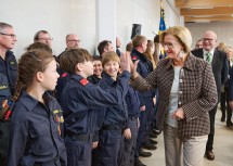 Landeshauptfrau Johanna Mikl-Leitner mit der Feuerwehrjugend, die sich über die neuen Räumlichkeiten freut, und Bezirkshauptmann Günter Stöger