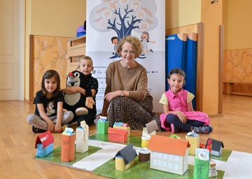 (v.l.n.r.): Familien-Landesrätin Christiane Teschl-Hofmeister (3.v.l.) mit Ronja, Daniel, und Anna, die in ihrem Kindergarten an einem der grenzüberschreitenden Projekte teilnehmen.