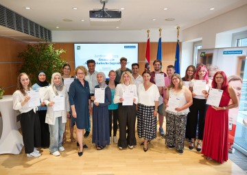 Familien-Landesrätin Christiane Teschl-Hofmeister und Barbara Trettler, Geschäftsführerin der NÖ Familienland GmbH, mit den Absolventinnen und Absolventen des Grundkurses „Außerschulische Jugendarbeit“.