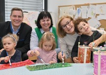 Bürgermeister Christoph Kaufmann, Kindergartenleiterin Ingrid Hontsch und Landeshauptfrau Johanna Mikl-Leitner mit Kindern bei den Vorbereitungen auf das Martinsfest (v.l.n.r.).